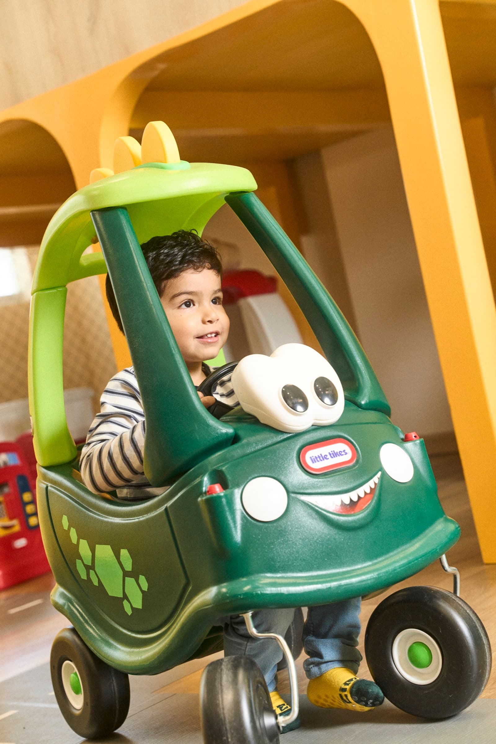 Child playing in a toy car